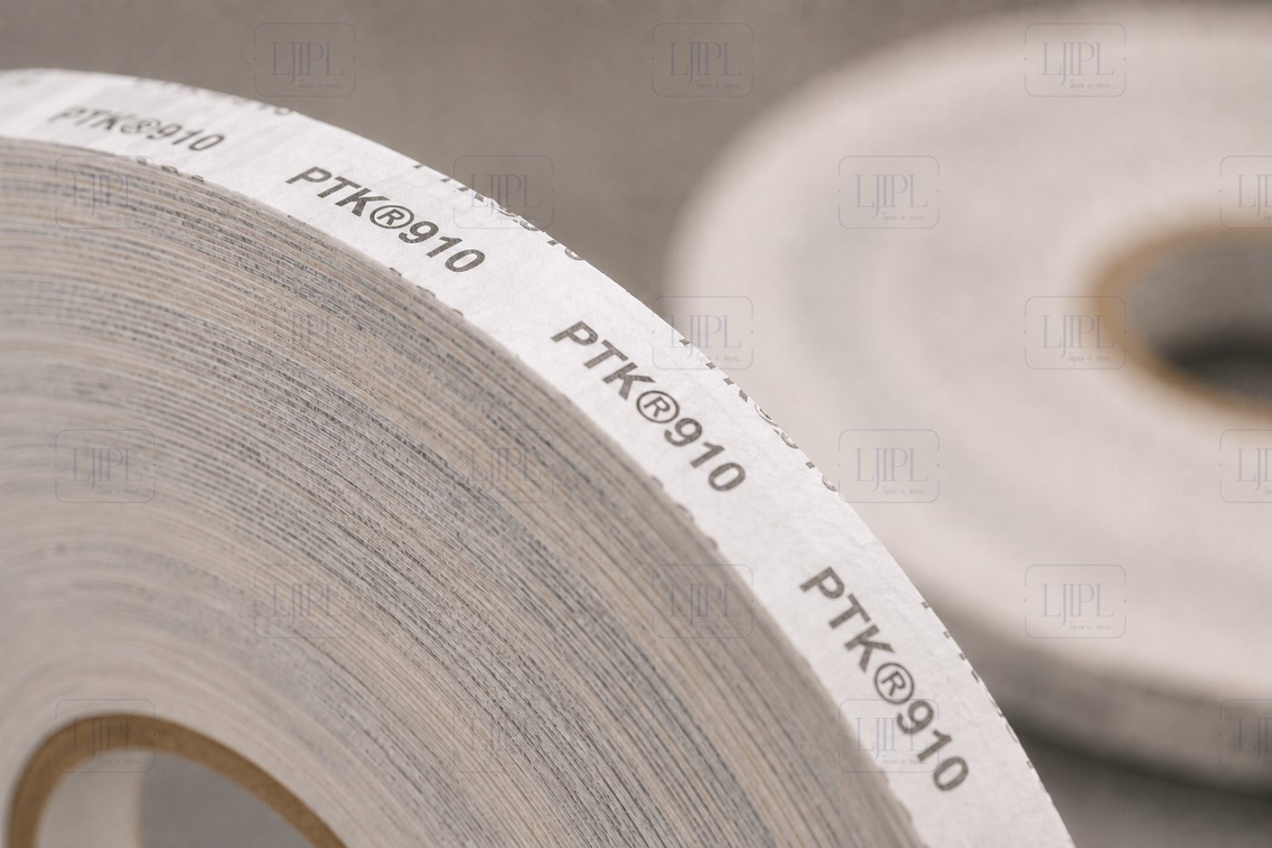 Close-up of the PTK 910 printed release liner showing the signature PTK®910 branding along the tissue tape reel edge
